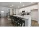 Open concept kitchen features white cabinets, island with seating, and hardwood floors at 732 Apple Churn Dr, Fuquay Varina, NC 27526