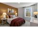 Calm bedroom with a mustard yellow accent wall and a comfy bed at 732 Apple Churn Dr, Fuquay Varina, NC 27526