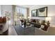 Cozy living room with a leather sofa, large windows, and a glass coffee table at 732 Apple Churn Dr, Fuquay Varina, NC 27526