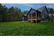 Two-story home with dark exterior, screened porch, and grassy backyard at 1147 Henderson Tanyard Rd, Pittsboro, NC 27312