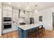 Modern kitchen island with blue cabinetry, quartz countertops, and bar stools at 465 Douglas Falls Dr, Wendell, NC 27591