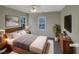 Virtually staged bedroom with wood bed frame, neutral walls, and a large window at 3181 Hardie St, Creedmoor, NC 27522