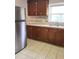 Kitchen boasts wood cabinets and tile flooring at 327 Ranch Farm Rd, Raleigh, NC 27603