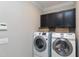 Laundry room with washer, dryer, and upper cabinets at 5356 Cypress Ln, Raleigh, NC 27609