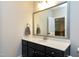 Clean bathroom with dark vanity, marble countertop and large mirror at 5356 Cypress Ln, Raleigh, NC 27609