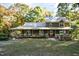 Front view of a two-story green house with a wrap-around porch at 7925 S Highway 55, Willow Springs, NC 27592