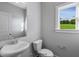 Clean powder room with white pedestal sink and a window overlooking the yard at 71 Macy Cir, Wendell, NC 27591