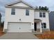 Two-story home with white siding, gray brick accents, and a two-car garage at 210 Bay Laurel Dr, Sanford, NC 27332
