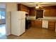 Kitchen with wood cabinets, white appliances, and tiled floor at 733 Carlisle St, Raleigh, NC 27610