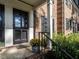 Black front door with sidelights, brick entryway, and potted mums at 3736 Jamestown Cir, Raleigh, NC 27609