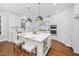 Island kitchen with white cabinets, quartz countertops, and stainless steel appliances at 3007 Olde Weatherstone Way, Cary, NC 27513