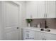 Small wet bar with white cabinets, quartz countertops, and a stylish backsplash at 87 Macy Cir, Wendell, NC 27591