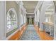 Elegant hallway with hardwood floors, arched windows, and a chandelier at 90118 Hoey, Chapel Hill, NC 27517