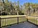 Deck overlooks a spacious backyard with lush greenery and tree line at 79 Tulipfield Way, Benson, NC 27504