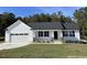 One-story house with white siding, a two-car garage, and a covered porch at 79 Tulipfield Way, Benson, NC 27504