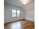 Simple bedroom with hardwood floors and a large window with wooded views at 013 Bartley Holleman Rd # 13, New Hill, NC 27562