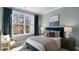 Serene bedroom with large windows and a navy blue bed frame at 734 Apple Churn Dr, Fuquay Varina, NC 27526