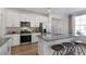 Modern kitchen with a large island, stainless steel appliances, and white cabinetry at 734 Apple Churn Dr, Fuquay Varina, NC 27526