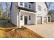 White and black modern farmhouse with a covered entryway and a garage at 329 & 331 Roxboro St, Haw River, NC 27258