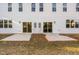 Rear view of a modern home with two sliding glass doors leading to a patio at 329 & 331 Roxboro St, Haw River, NC 27258
