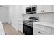 Modern kitchen with stainless steel appliances and white cabinets at 329 & 331 Roxboro St, Haw River, NC 27258
