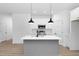 Modern kitchen with white cabinets, gray island, and black pendant lights at 329 & 331 Roxboro St, Haw River, NC 27258
