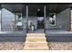 Covered porch with wooden steps and two chairs at 617 Orange Heights Loop Rd, Hillsborough, NC 27278