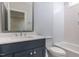 Clean bathroom with navy vanity and grey tile shower/tub combo at 370 Bellini Dr, Clayton, NC 27527