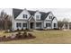 Two story home with gray siding, stone accents, and a landscaped lawn at 370 Bellini Dr, Clayton, NC 27527