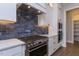Modern kitchen with white cabinets, blue tile backsplash, and stainless steel appliances at 370 Bellini Dr, Clayton, NC 27527