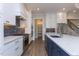 Modern kitchen with white cabinets, blue tile backsplash, and a large island with a navy blue base at 370 Bellini Dr, Clayton, NC 27527