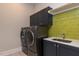 Laundry room with dark cabinets, green tile, and modern appliances at 370 Bellini Dr, Clayton, NC 27527
