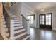 Grand staircase with wood treads, white risers, and black metal railing at 370 Bellini Dr, Clayton, NC 27527
