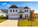 Two-story home with gray siding, a three-car garage, and a well-maintained lawn at 52 E Piston Pt, Clayton, NC 27520