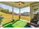 Relaxing screened porch with artificial turf and wicker furniture at 52 E Piston Pt, Clayton, NC 27520