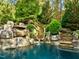 Inviting pool with waterfall feature and lush landscaping at 110 Bywater Way, Chapel Hill, NC 27516