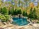 Stunning pool with waterfall feature surrounded by lush landscaping at 110 Bywater Way, Chapel Hill, NC 27516