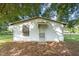 Small white outbuilding with a single door and window at 9847 Snow Camp Rd, Snow Camp, NC 27349
