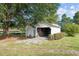 White outbuilding with attached carport and green grass at 9847 Snow Camp Rd, Snow Camp, NC 27349