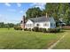 White house with brick chimney, surrounded by lush green lawn at 9847 Snow Camp Rd, Snow Camp, NC 27349