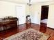 Living room featuring hardwood floors, a piano, and access to other rooms at 203 Peace St, Oxford, NC 27565