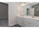 Double vanity bathroom with white cabinets, a large mirror, and a view of a bedroom at 100 Lemon Drop Ln, Franklinton, NC 27525