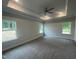 Spacious bedroom with carpeted floor, ceiling fan, and multiple windows at 100 Lemon Drop Ln, Franklinton, NC 27525