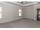 Well-lit bedroom featuring carpet flooring, neutral walls, and a ceiling fan. Offers access to hallway at 100 Lemon Drop Ln, Franklinton, NC 27525