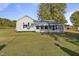 White house with screened porch and large yard, offering a peaceful setting at 2494 Joel Johnson Rd, Lillington, NC 27546