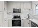 Modern kitchen with white shaker cabinets, quartz countertops and stainless steel appliances at 623 W Club Blvd, Durham, NC 27701