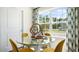 Bright dining area with glass table and yellow chairs, overlooking a wooded area at 113 Holmes Corner Dr, Smithfield, NC 27577