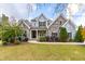 Two-story stone and gray house with a large front yard and landscaping at 204 Harvest Ln, Pittsboro, NC 27312