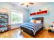 bedroom with striped bedding, built-in shelves, and hardwood floors at 204 Harvest Ln, Pittsboro, NC 27312