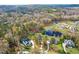 Aerial view of a house and lot in a wooded neighborhood near a pond at 204 Harvest Ln, Pittsboro, NC 27312